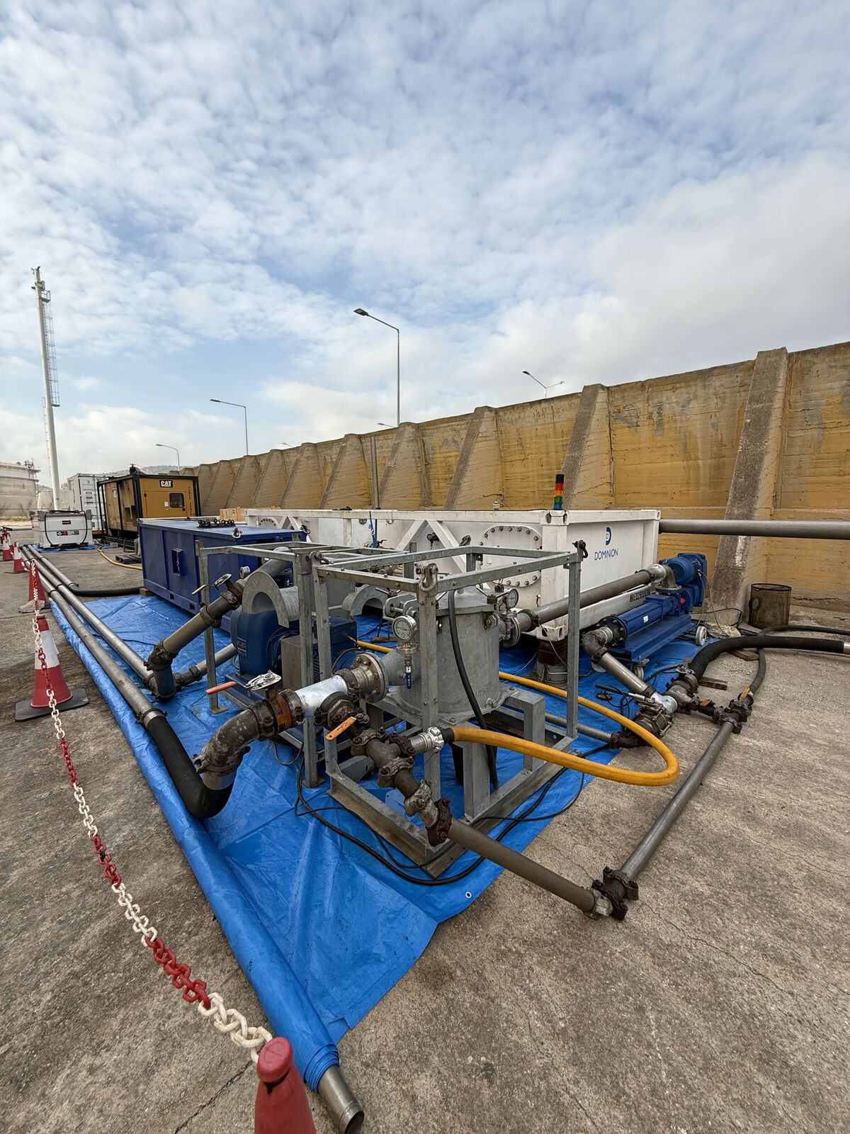 Pumping skid manifold on containment tarp during a tank job