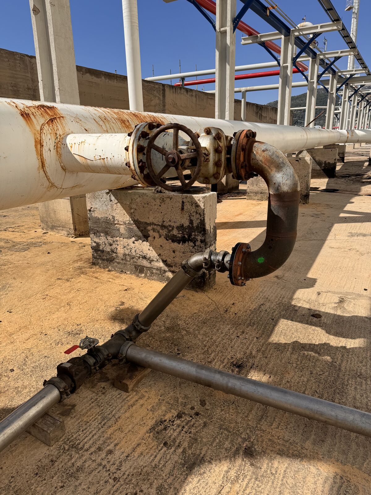 Pipework between storage tanks at dusk