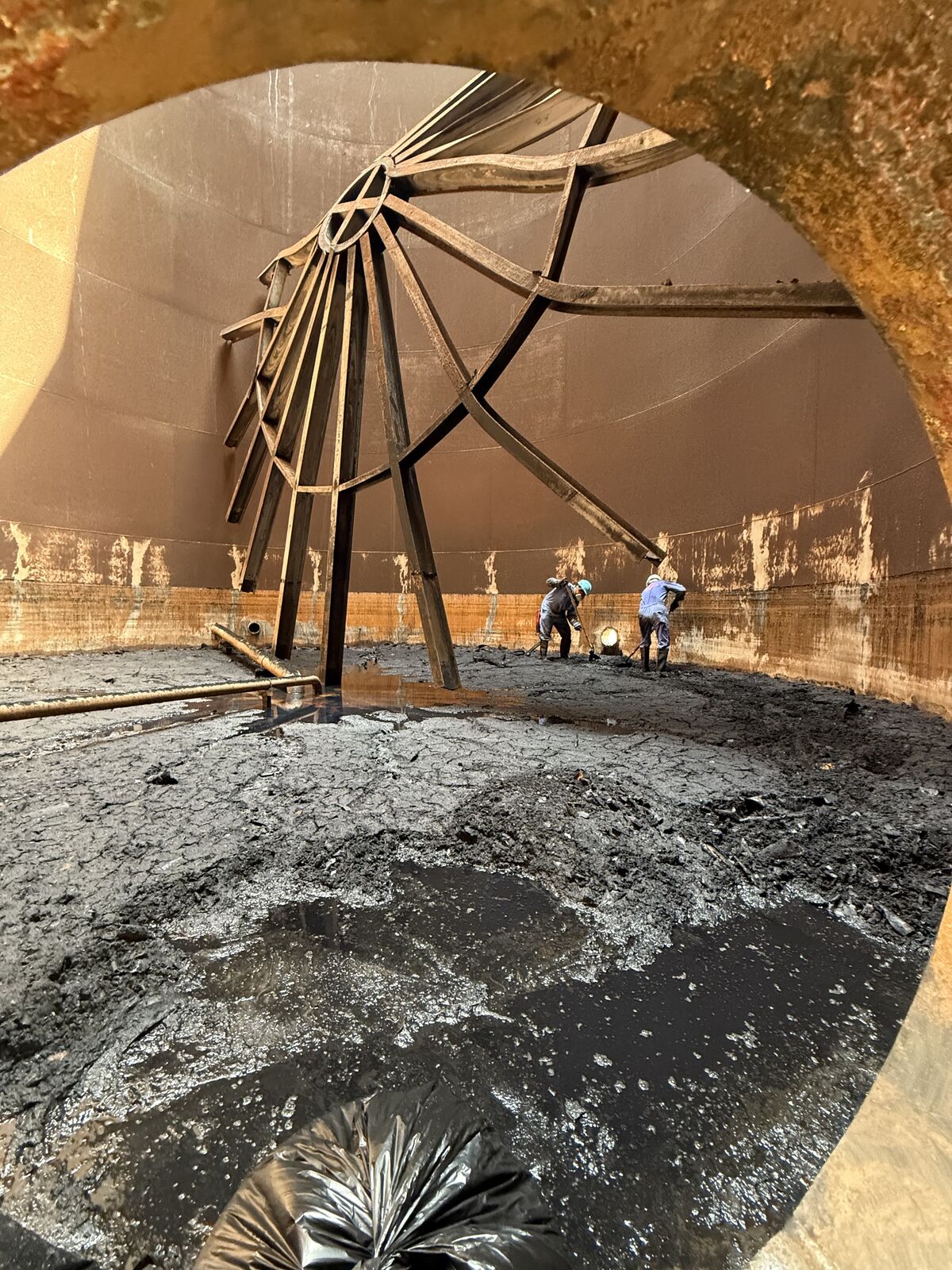 Operators inside a storage tank during a cleaning operation
